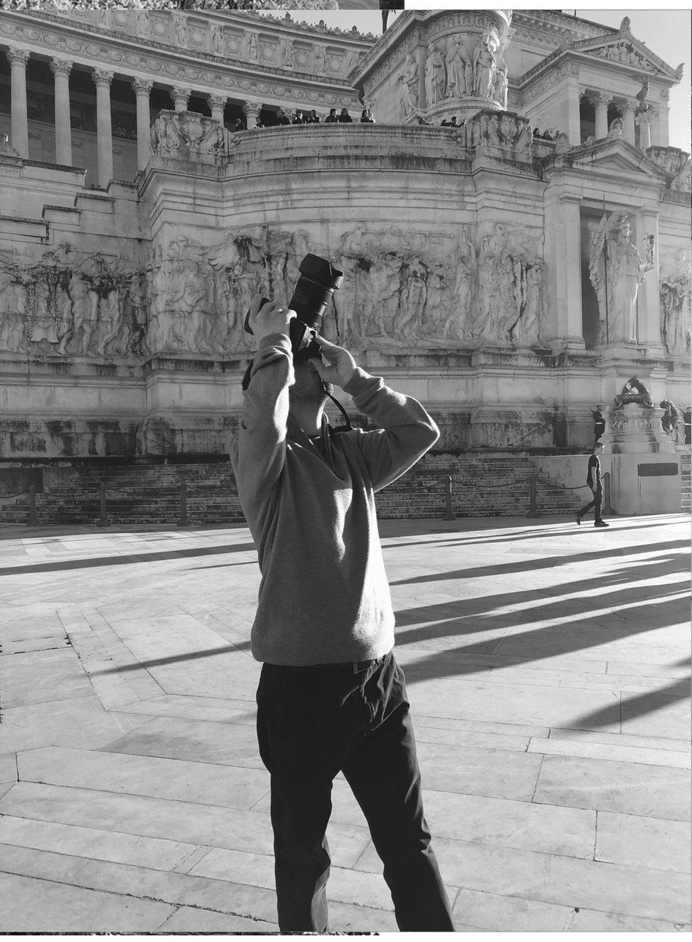 Carlos apunta su cámara hacia arriba, frente a la columnata de un edificio monumental.